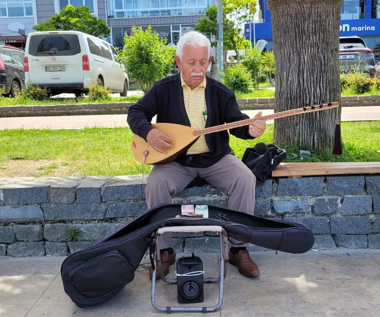 Koyunların peşinde başlayan bağlama sevdasını sahilde küçük konserler vererek sürdürüyor